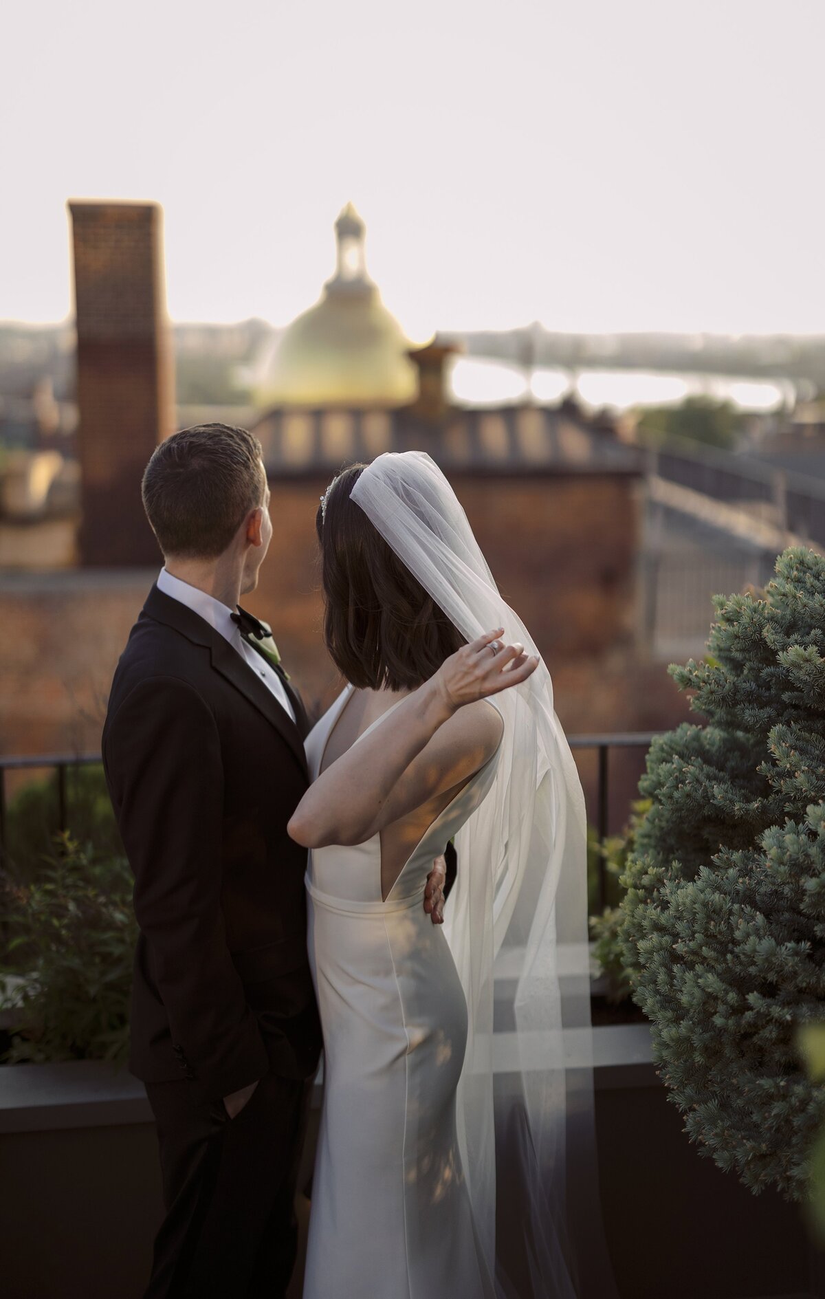 Bride and Groom overlook Boston statehouse during rooftop wedding in Boston.