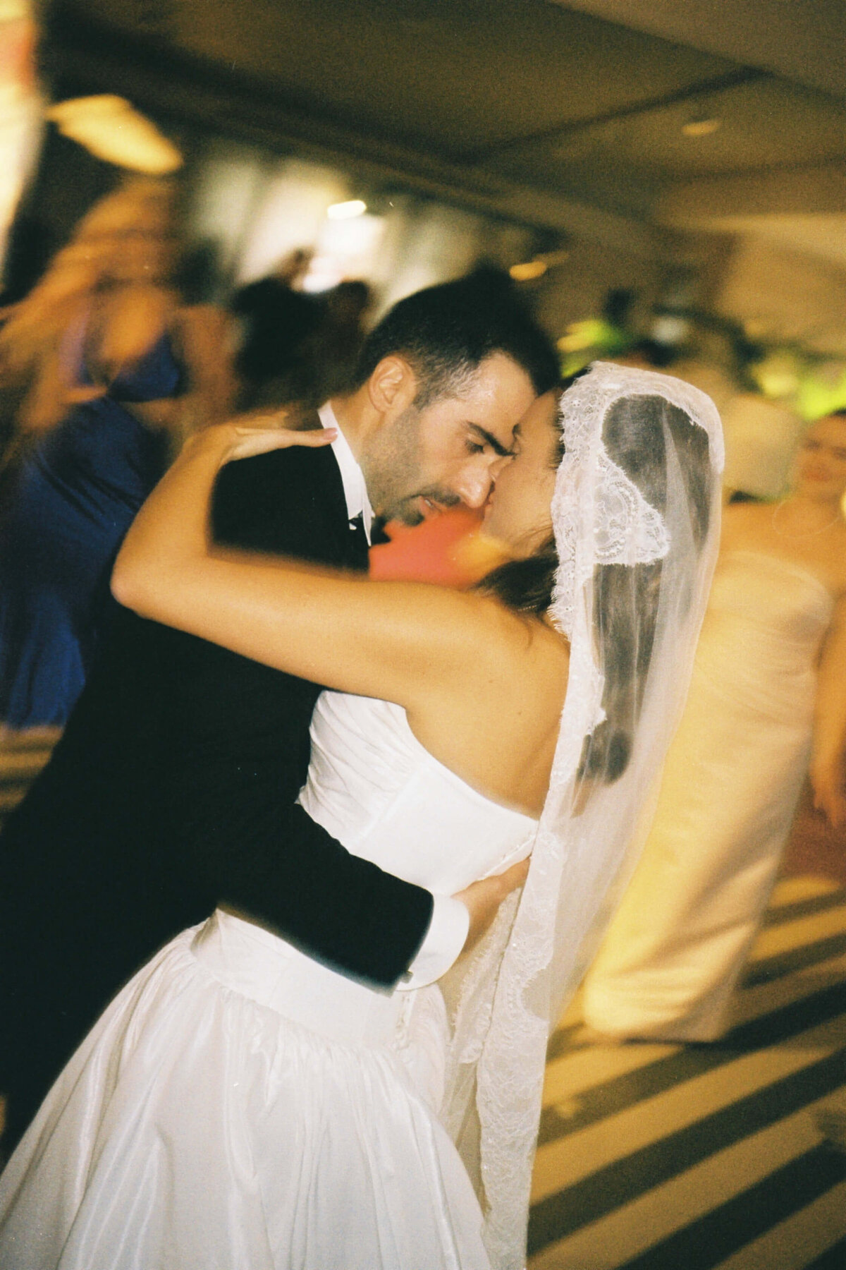 Bride waving her hand in the air while dancing with groom at reception

