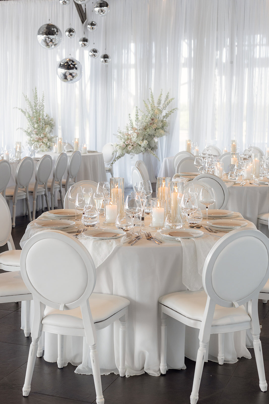 The Science Centre decked out with a disco ball, elegant curtains, and floral arrangements for a wedding reception.