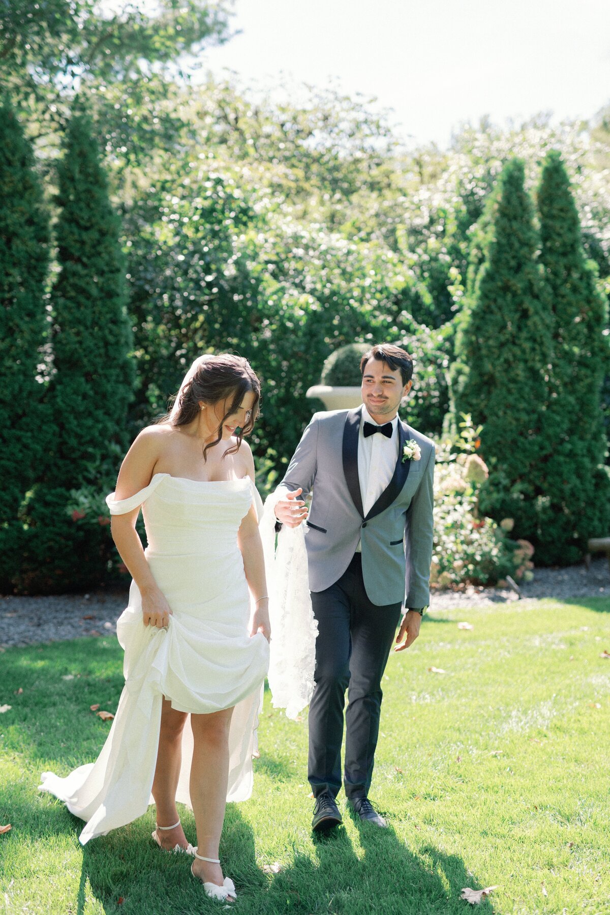 Bride and Groom walk outside for portraits by Lacey Graham Wedding photographer