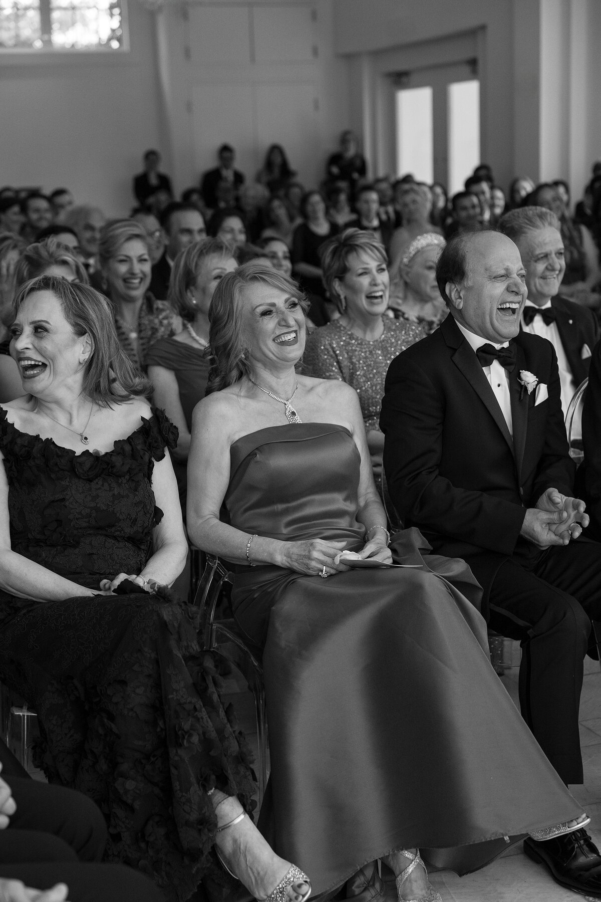 Guests laugh during Persian wedding ceremony at Belle Mer, Newport.