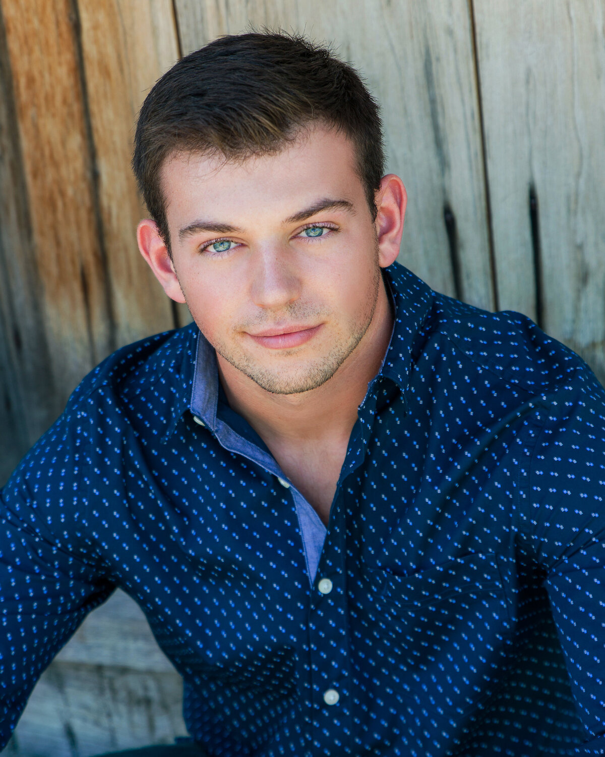 Senior portrait yearbook photo of buy from Victor Senior High School wood door background with blue eyes