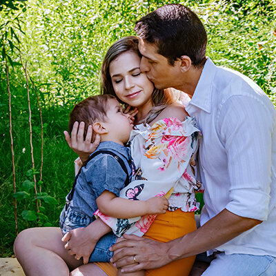 A family of three embraces in a beautiful field in Surrey, BC