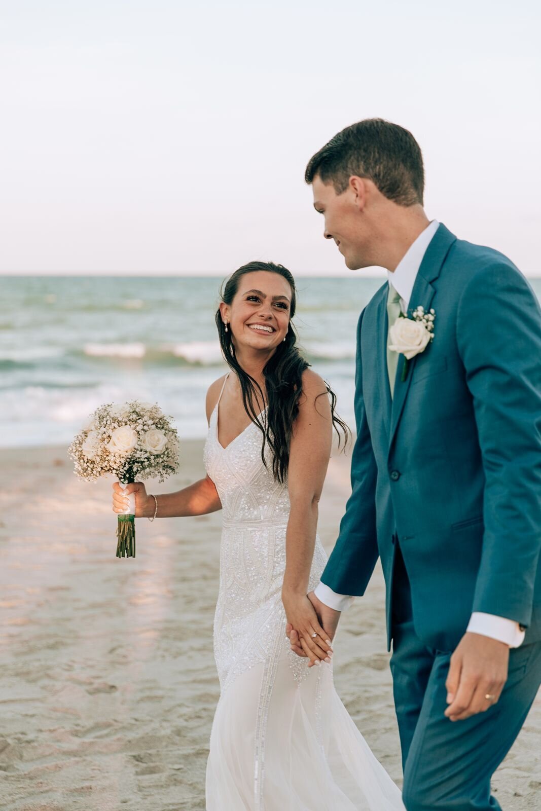 candid moment of bride and groom on the beach