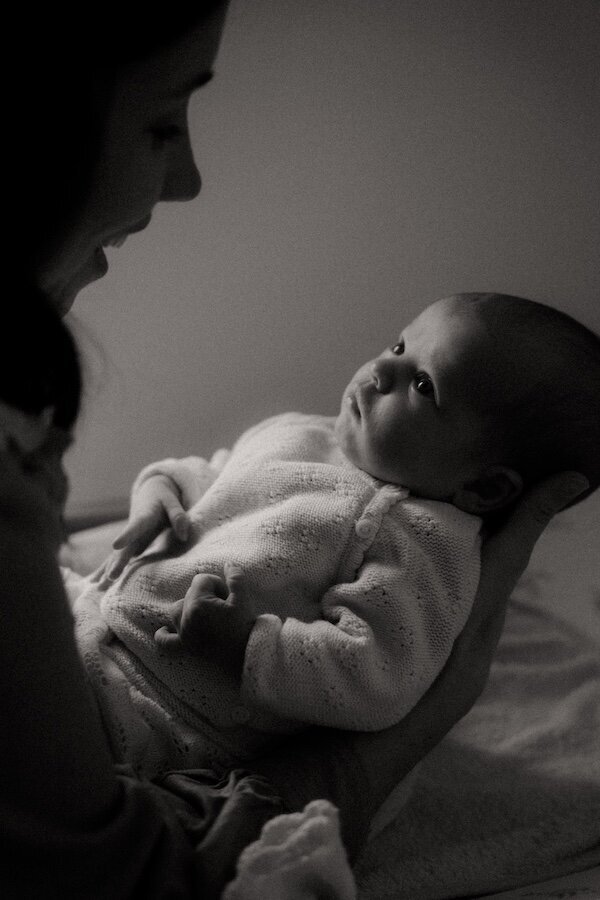 Noir et blanc. La mère et son bébé se regardent avec intensité. Séance maternité par Kamescop, photographe naissance en Bretagne.