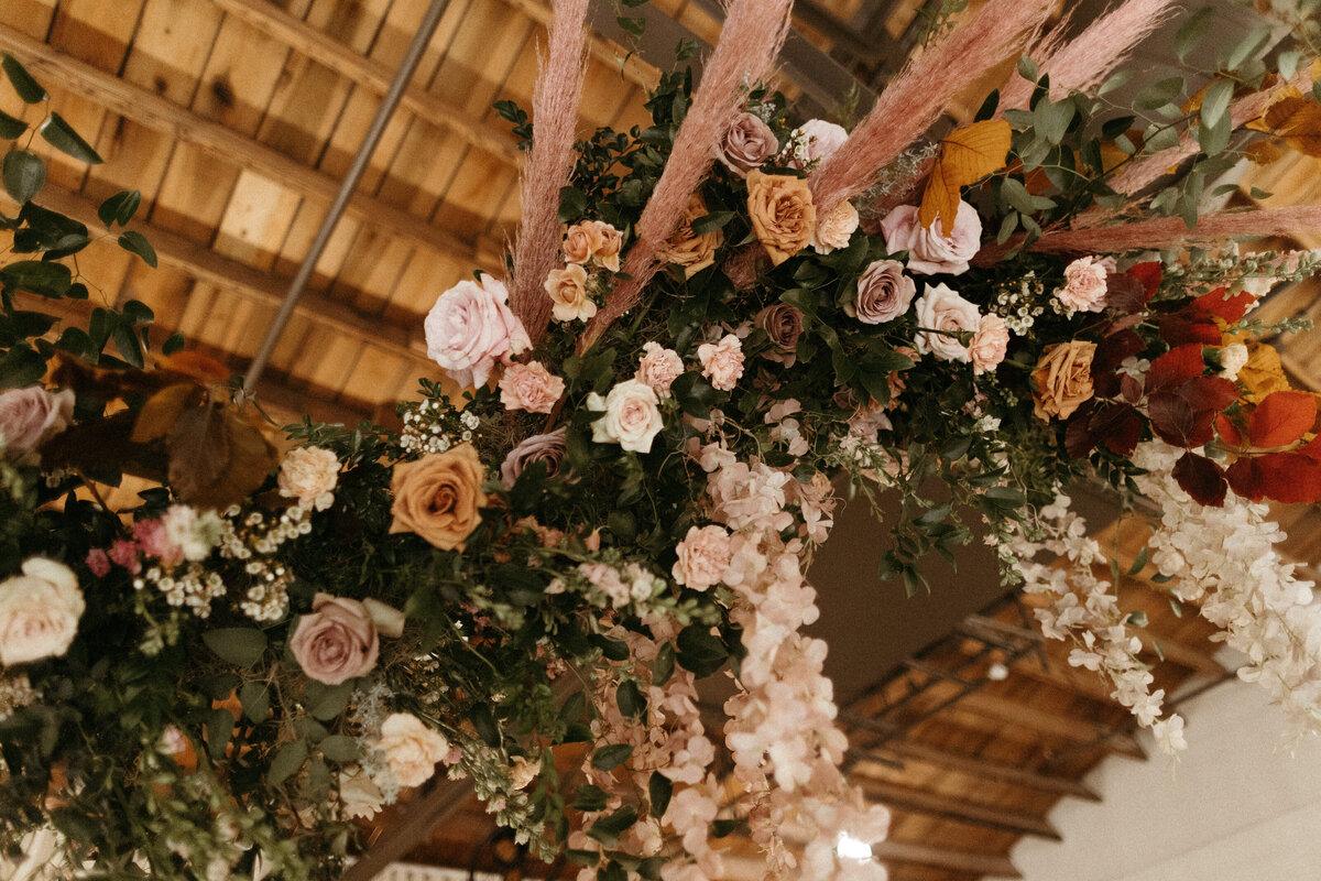 Stunning floral installations bring warmth to this Great Gatsby inspired wedding with florals of terra cotta, dusty pink, and burgundy hues. Petal heavy roses, copper beech, and pink pampas grass accents. Designed by Rosemary and Finch in Nashville, TN.