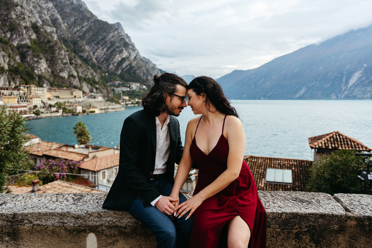 Lake Garda honeymoon session couple walking by the water with city lights in the background