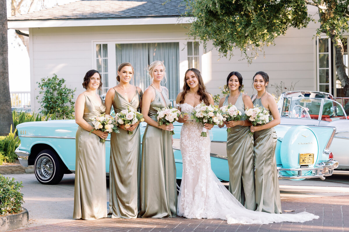 Bridesmaids by an antique blue car