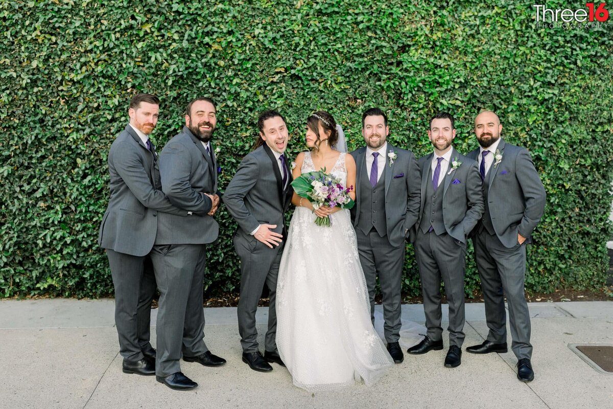 Groom and Groomsmen act off around the Bride