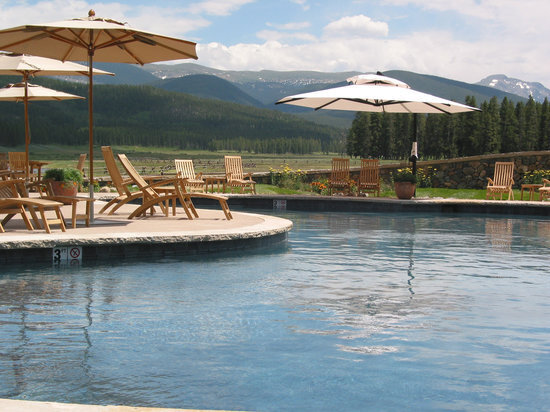 Pool at resort with chairs and umbrellas looking out at the pool