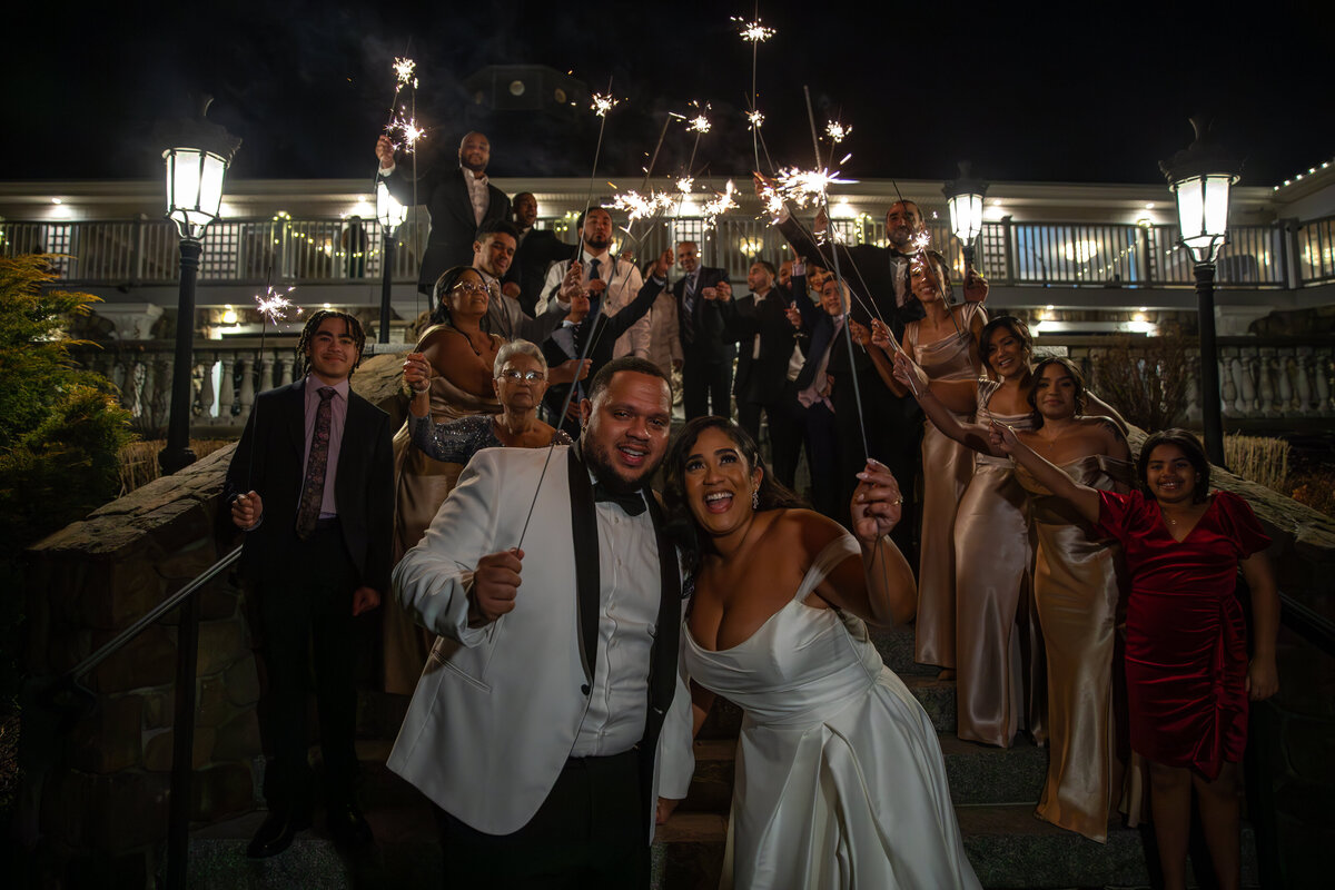 Bride and groom smiling in  group photo with wedding party