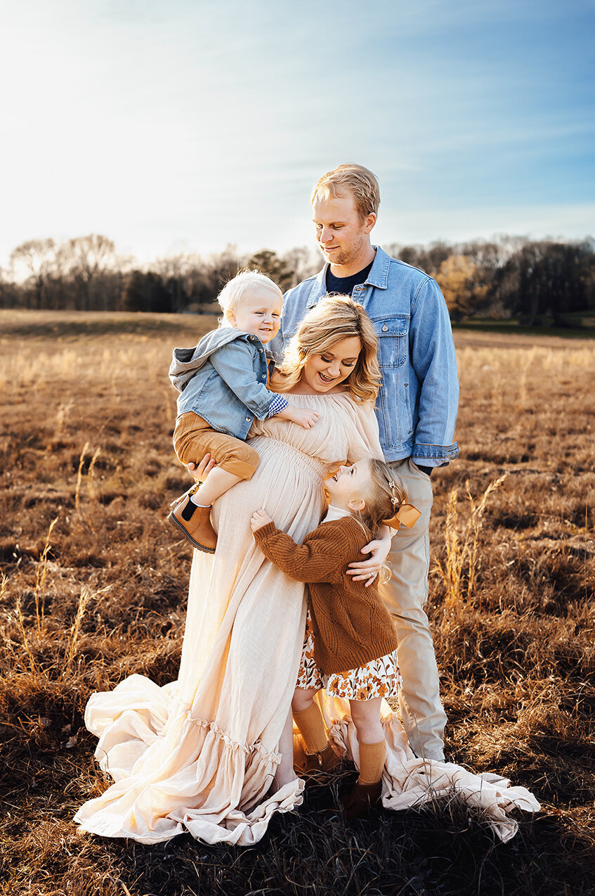 Family photographer in bowling green Kentucky. Family of 4 in a grassy field.  Glasgow Kentucky photographer
