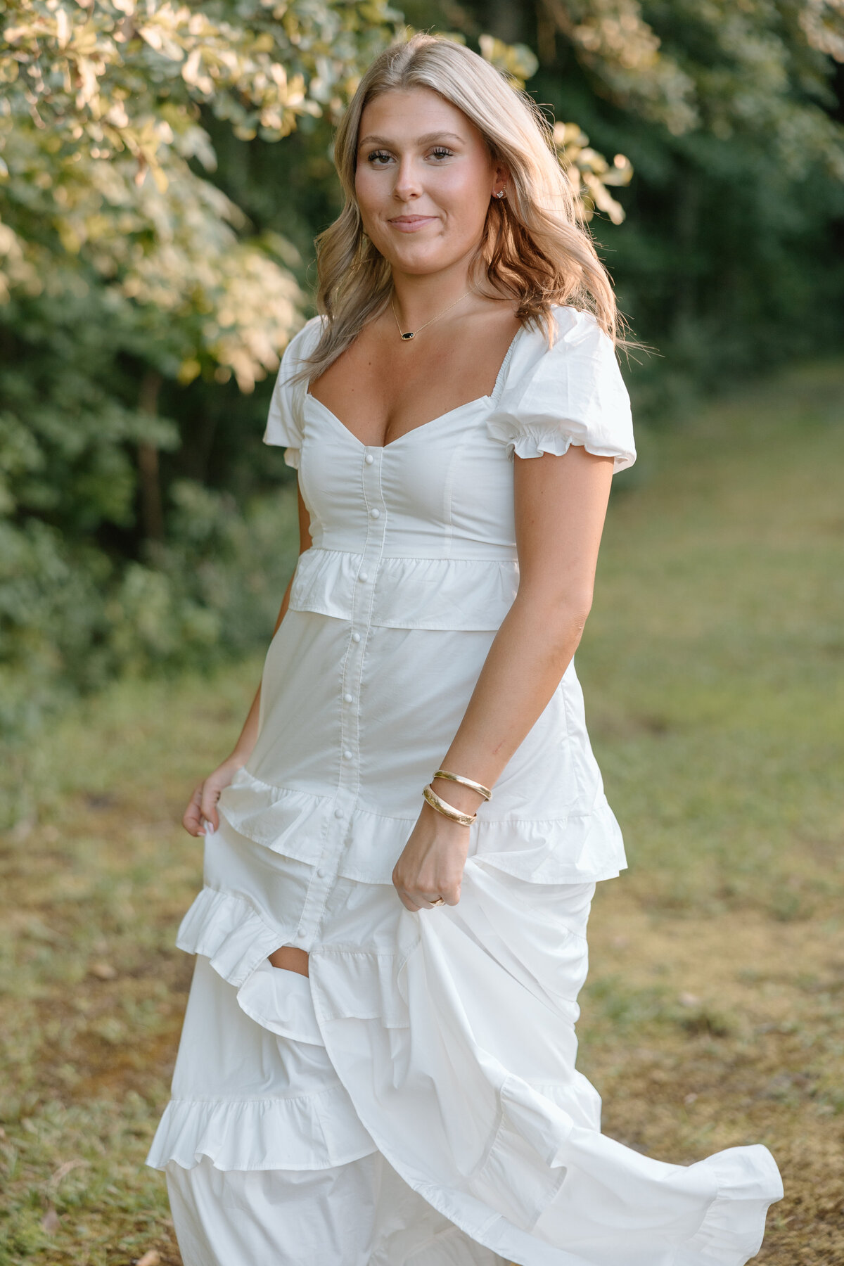 Senior photos on family property wearing  long white dress