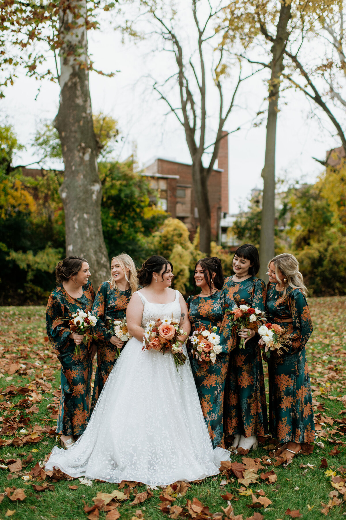 Bride smiling with bridesmaids holding bouquets