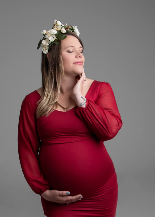 pregnant mother in a fitted red gown and a floral crown