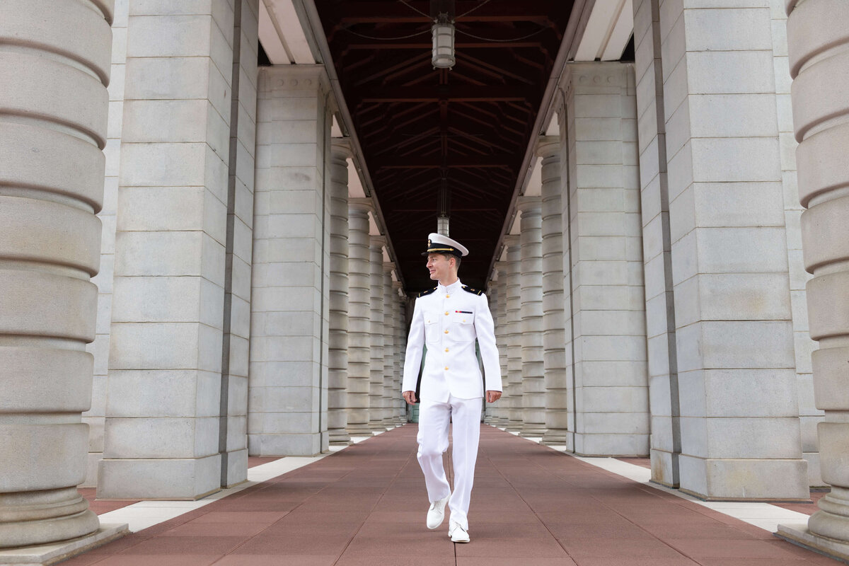 Naval Academy graduate walks in the hall on red beach.