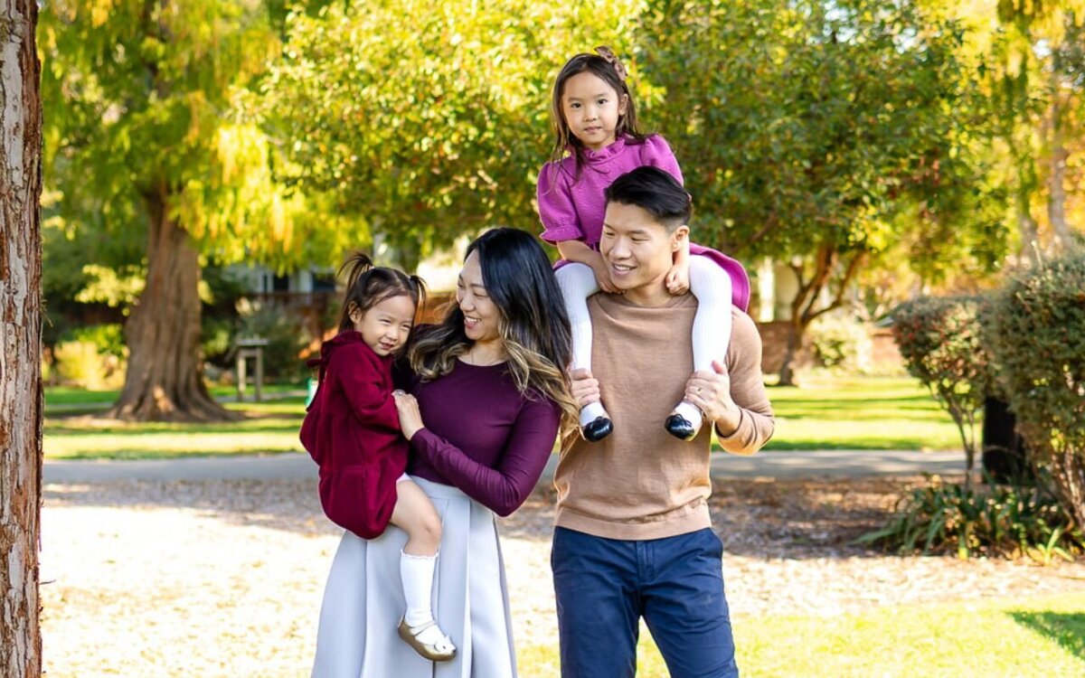 Family walking through a sunny San Mateo park surrounded by fall colors – Ellobelle Photography