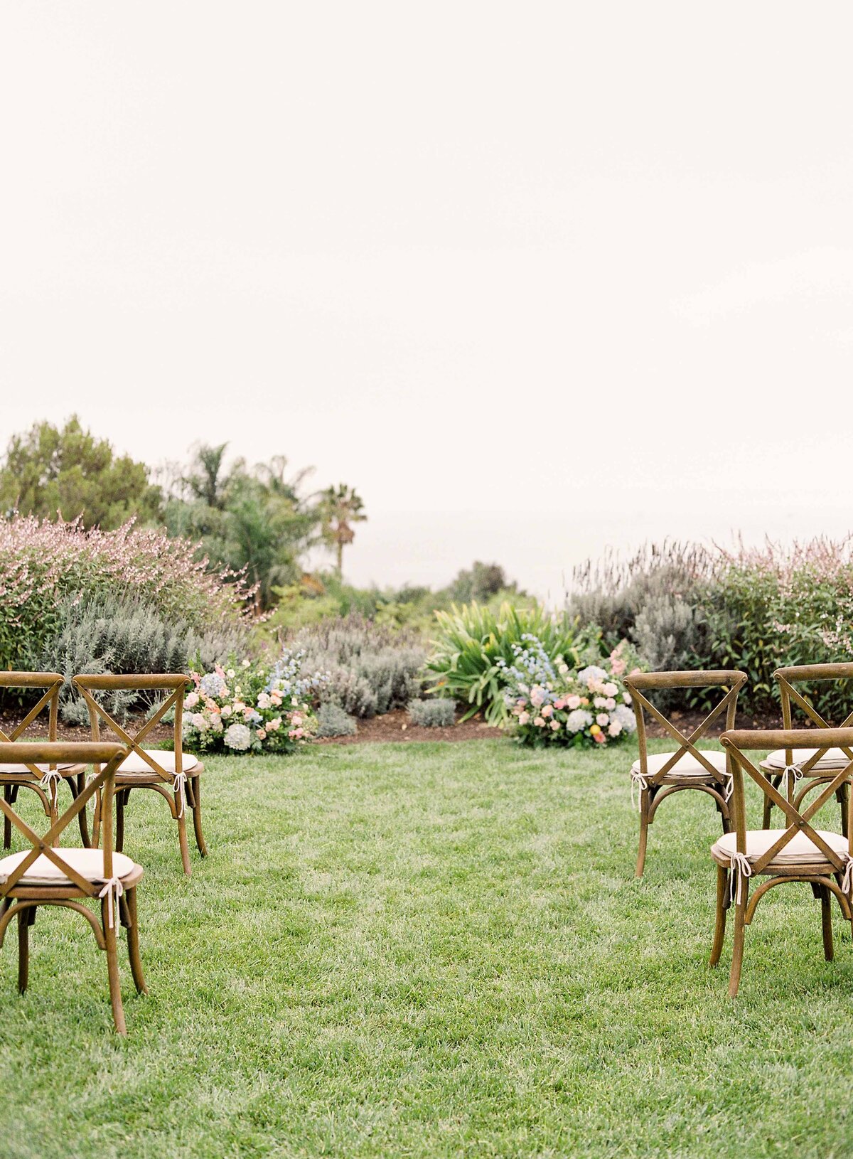 14santa-barbara-estate-wedding-planner-natural-ceremony-decor-aisle-markers-wooden-x-back-chairs