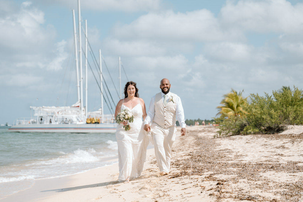 a bride and groom walking on the beach in Cozumel