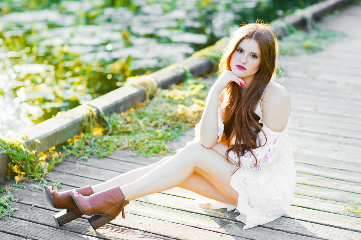 high school senior girl posing on pier