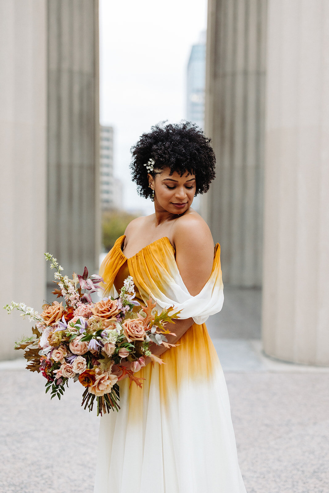 Beautiful autumnal bridal bouquet composed of roses, ranunculus, delphinium, clematis, lisianthus, and fall foliage floral hues of burnt orange, mauve, dusty rose, taupe, and lavender. Design by Rosemary and Finch in Nashville, TN.