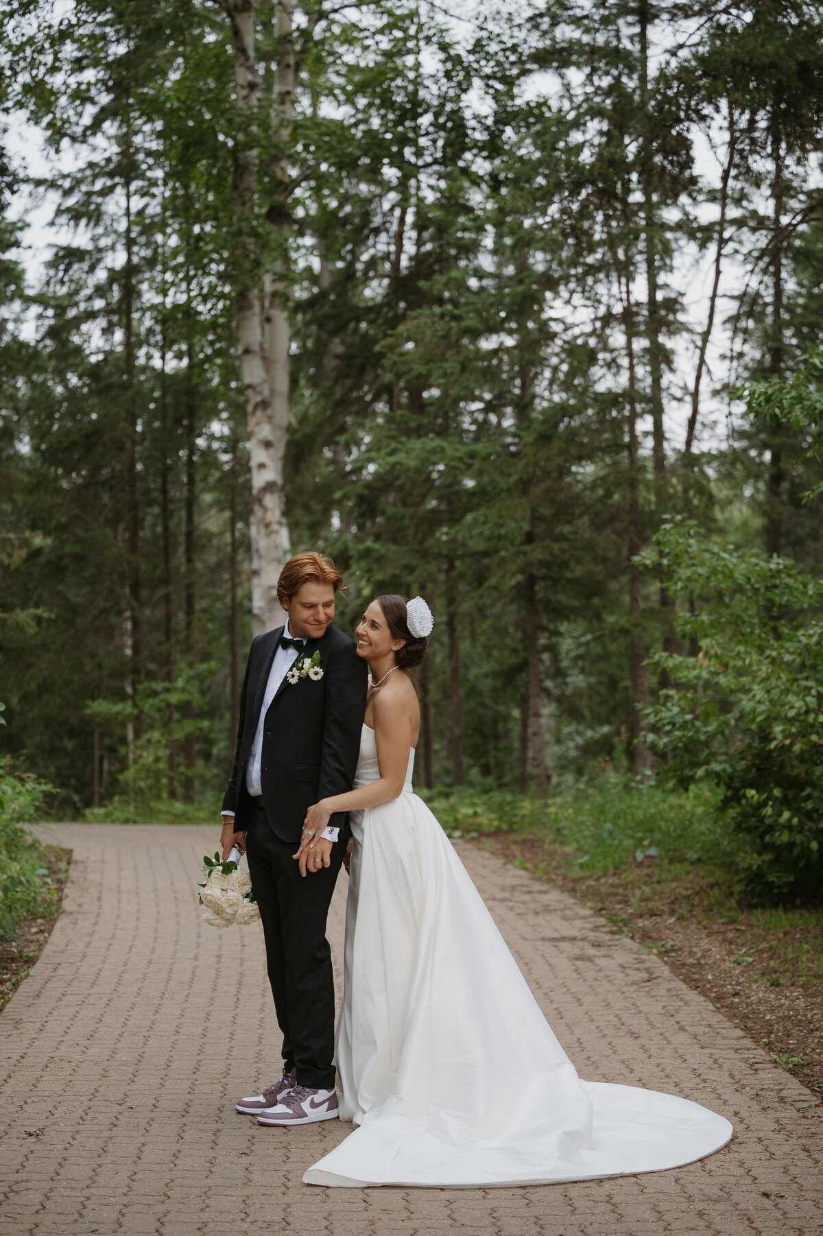 married couple standing amongst trees on wedding day