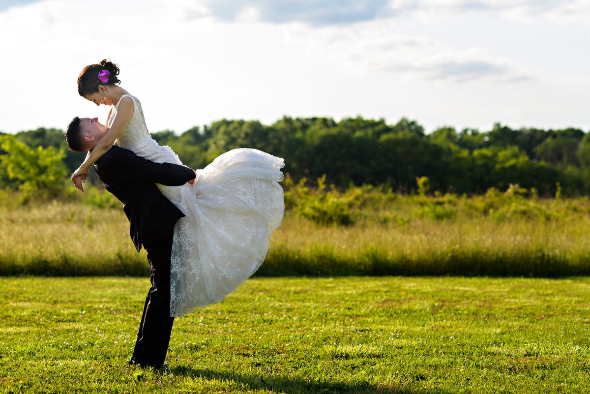 A groom spins his bride around in a field at their Pearl S Buck Estate Wedding.
