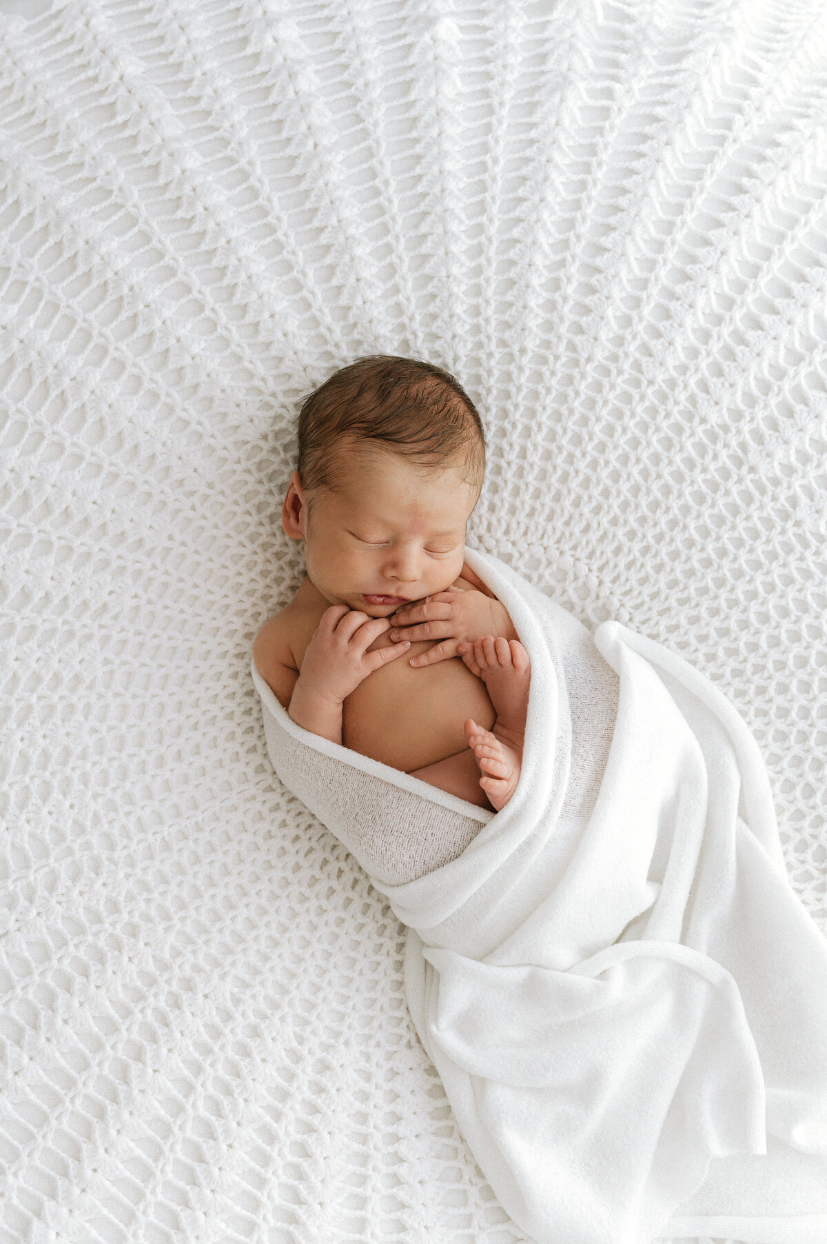 Baby lying on white blanket knitted by Grandma