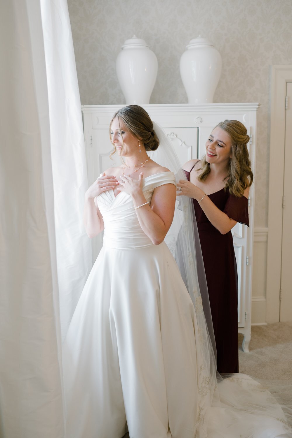 Bridesmaid helps bride get ready