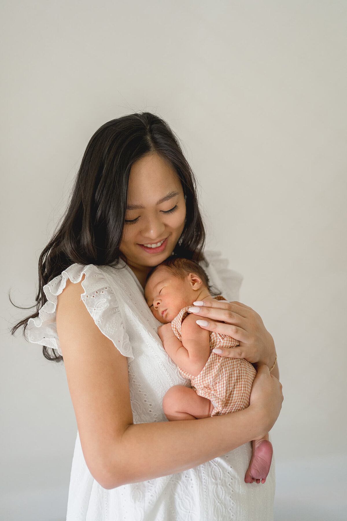 malaysian mum cuddling her newborn baby in bedroom postpartum and gold coast private hospital pindara