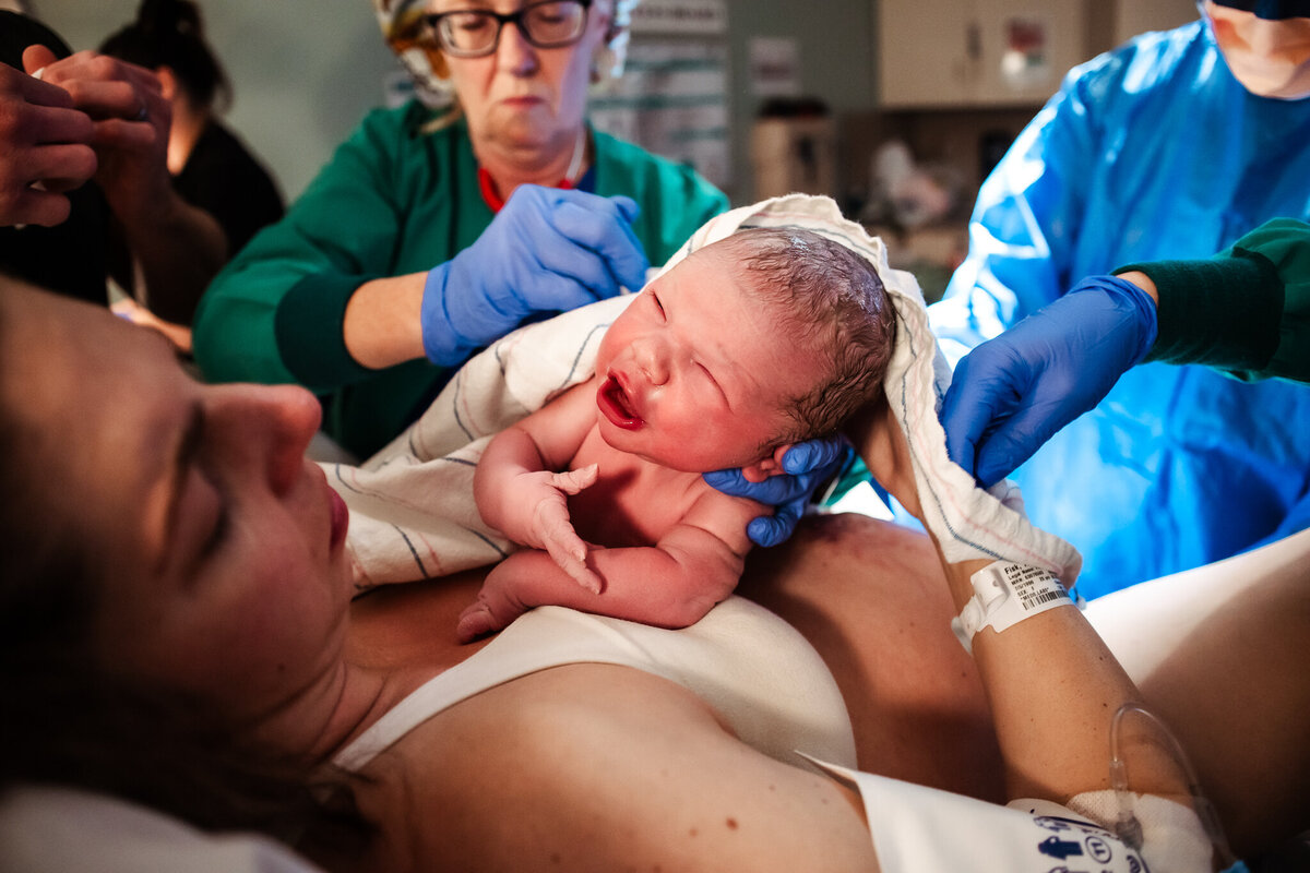 A baby cries as he is placed on his mother's chest for the first time at Memorial hospital in Modesto.  Modesto doula, Shayna Cox, was there to capture it all.