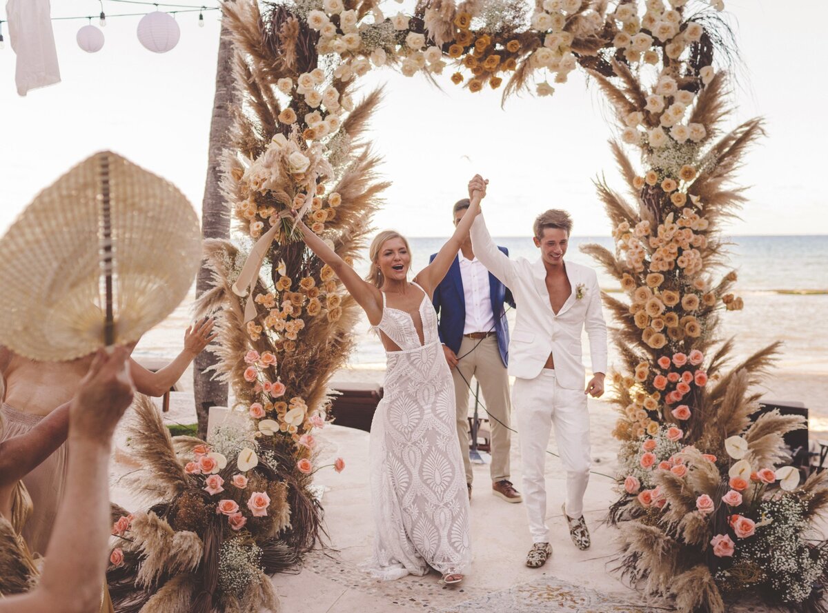 Bride and groom celebrate after being announced married at Riviera Maya wedding.