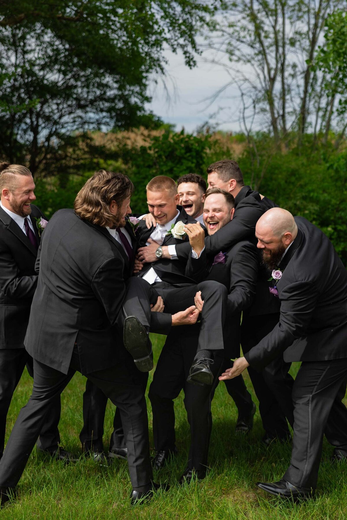 groomsman-picking-up-groom-candid-wedding