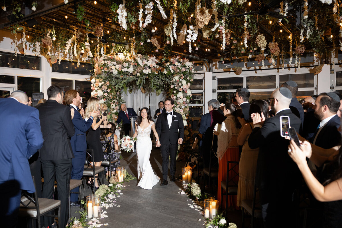 sarah and mark recess down the aisle during their wedding ceremony
