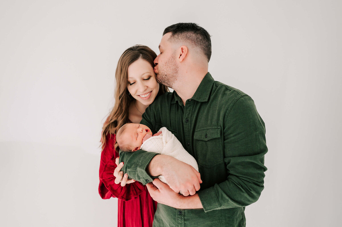 Springfield MO newborn photographer Jessica Kennedy of The XO Photography captures dad holding newborn and kissing wife