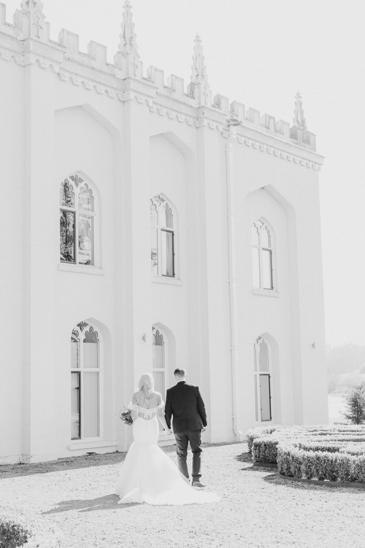 Bride and groom walking towards Combermere Abbey