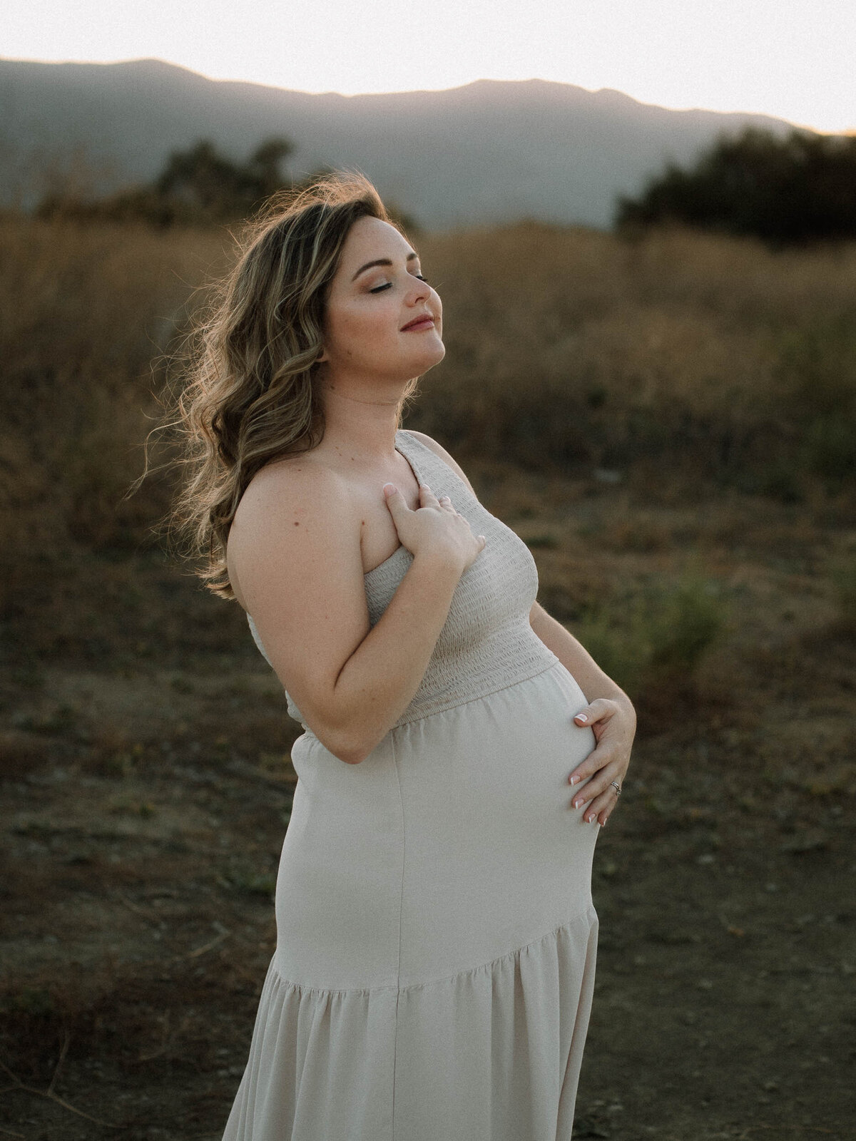 Outdoor maternity session in Temecula featuring a glowing expectant mother in soft neutral light.