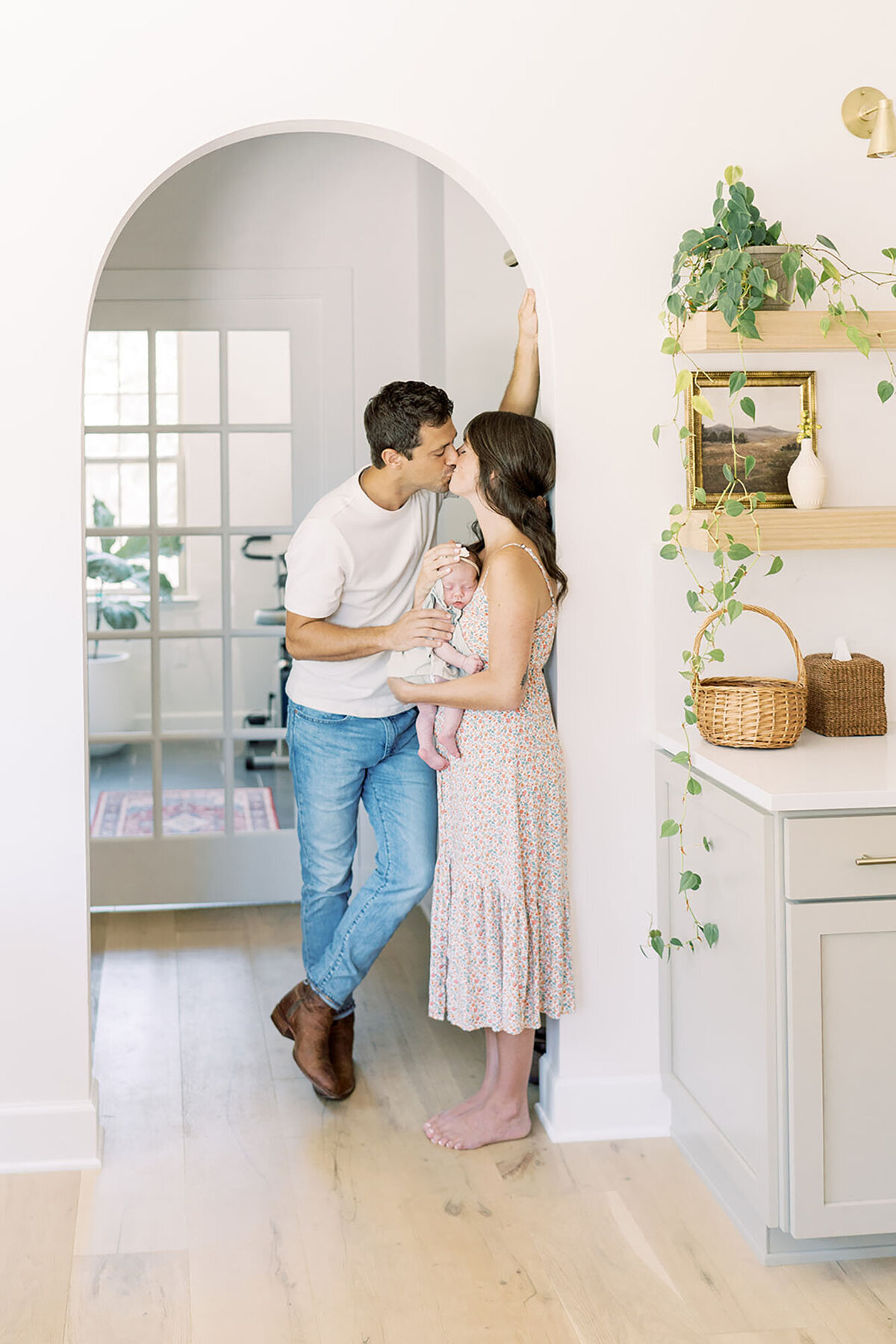 a mother and father stand in their home kitchen during their in home lifestyle newborn session