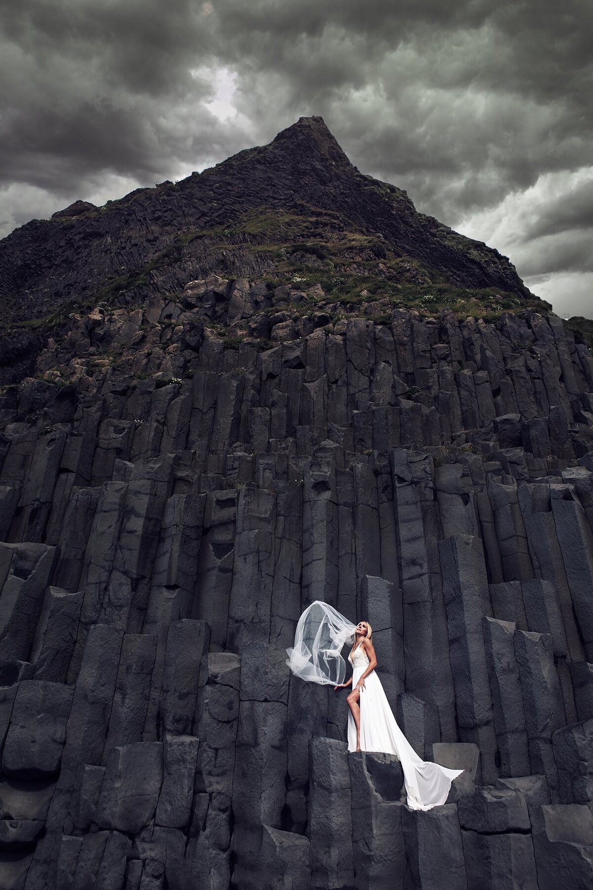bride-on-black-cliff-in-white-dress-iceland-destination-wedding-photography