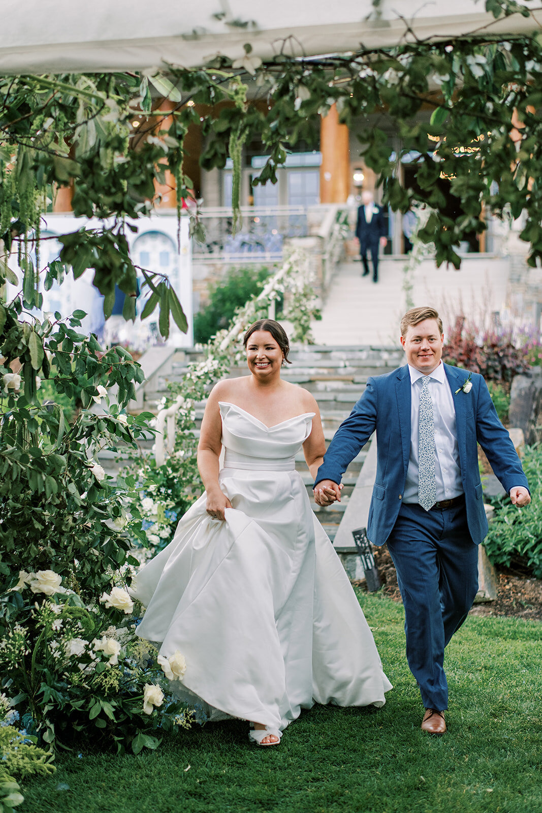 Bride and groom entering reception tent together onto a custom glossy patterned dance floor.