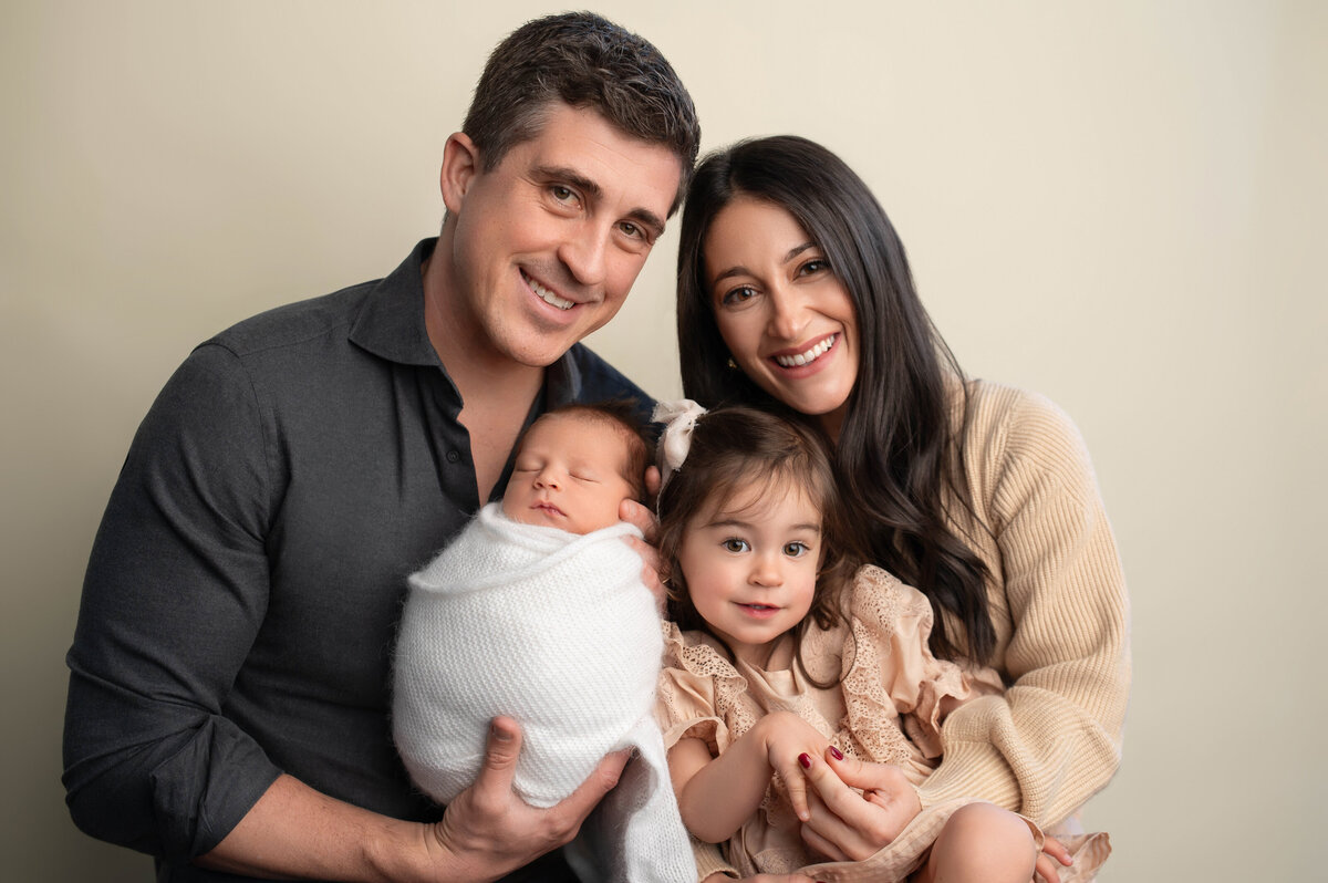 Stamford ct newborn photographer captures family portrait of parents with their 3 year old daughter and newborn son