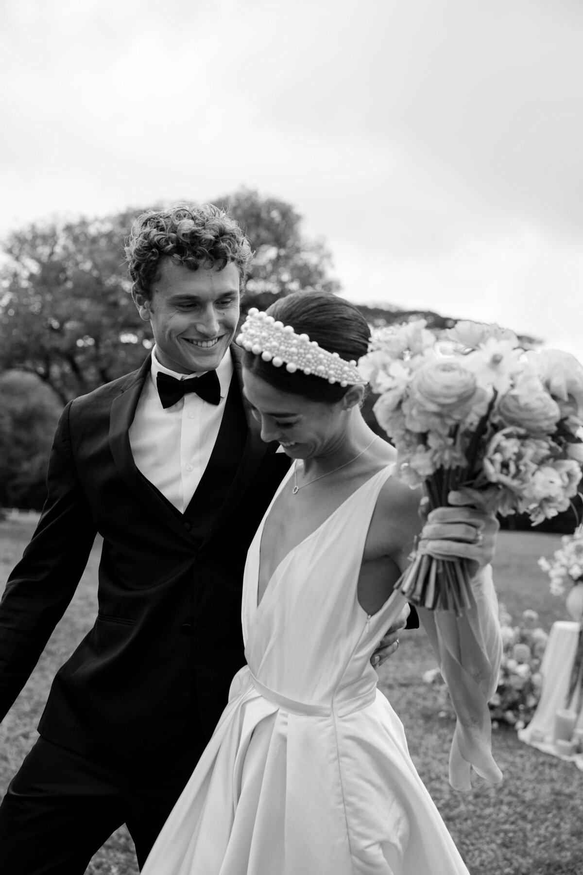 Bride and groom laughing joyfully as they walk down the aisle, captured in black and white — by Kate Winters Photography.