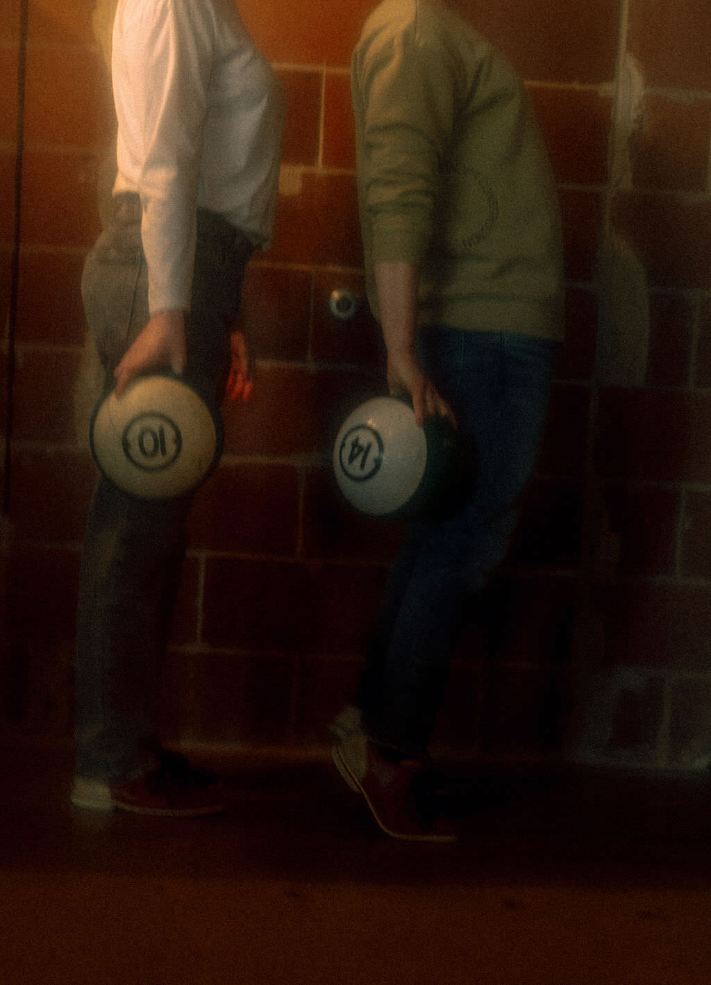 Two people holding bowling balls.