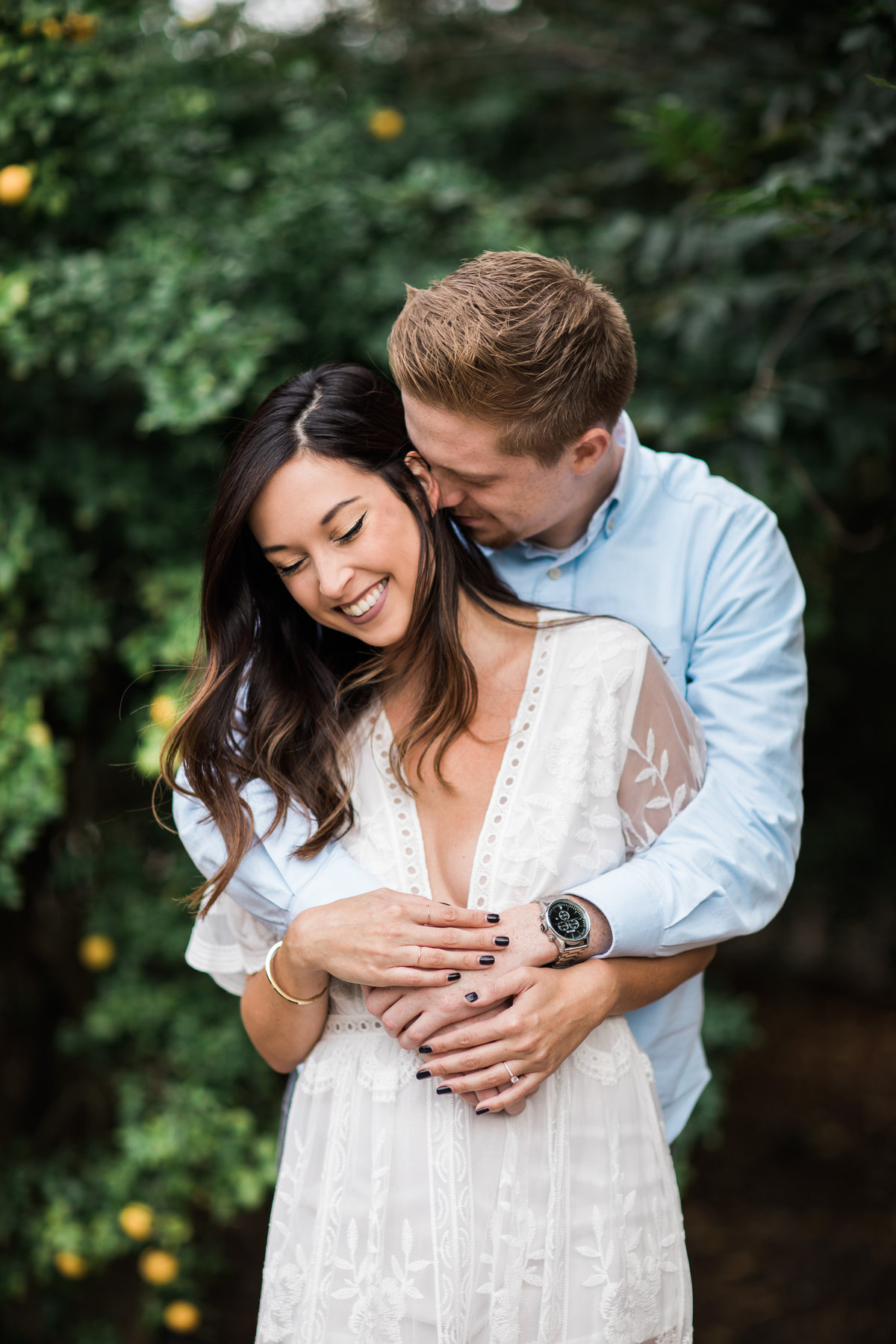 Young couple laughing and embracing during engagement session in Raleigh, North Carolina by Danielle Defayette