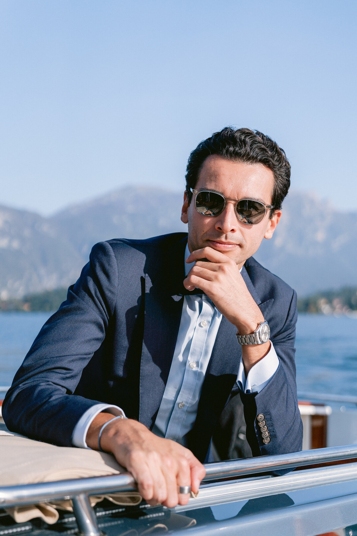 Groom wearing sunglasses on a private boat on Lake Como, Italy