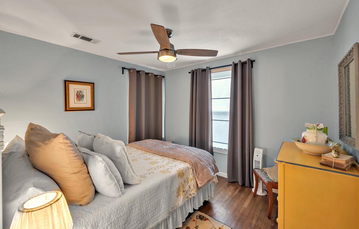 Bedroom with beautiful bedding in this three-bedroom, two-bathroom vacation rental house with free Wifi, fully equipped kitchen, office space, and room for six in downtown Waco, TX.
