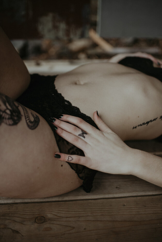 details of a girl in lingerie with tattoos on her ribs