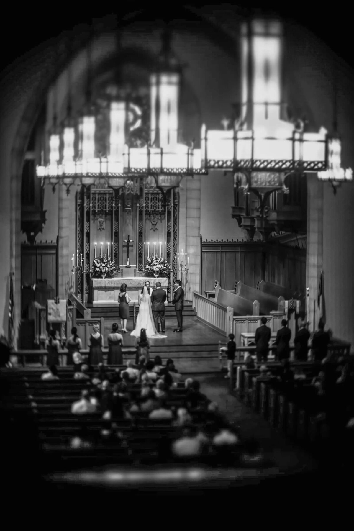 A striking black and white photo shows a bride and groom at the end of the church aisle