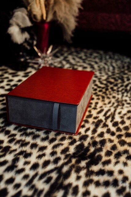 Boudoir photography image box with red cover on leopard rug in Lubbock, Texas photographer in Amarillo TX