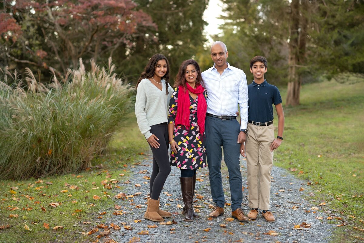 family of four smiling on gravel drive